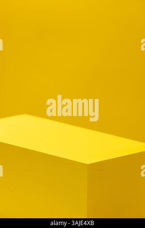 yellow painted wooden cube on yellow background Stock Photo