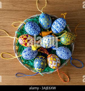 Colorful Easter eggs in various patterns create a stunning display in a woven basket. Stock Photo