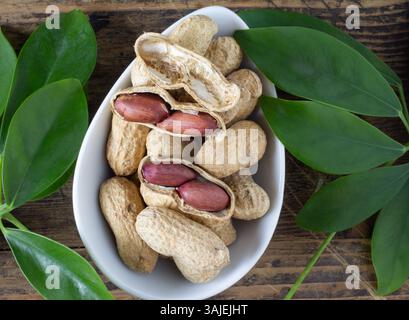 Peanuts in shell on a table with peanut leaves Stock Photo