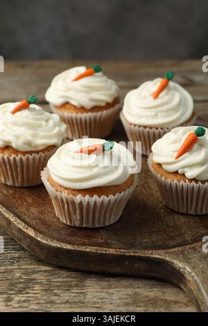 Delicious carrot cupcakes on wooden table against grey background, closeup Stock Photo
