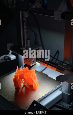 3D Printer Creating Vibrant Orange Prototype Model Stock Photo