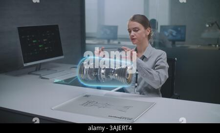 Female Engineer Uses Smartphone to Visualize 3D Holographic Model of Renewable Energy Engine in Futuristic Office. Advanced AI-based Design Software for Virtual Visualization Using Augmented Reality. Stock Photo