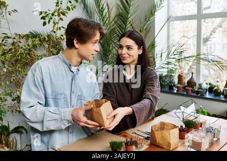 Creative couple collaborate, sharing ideas and materials in a lively studio. Stock Photo