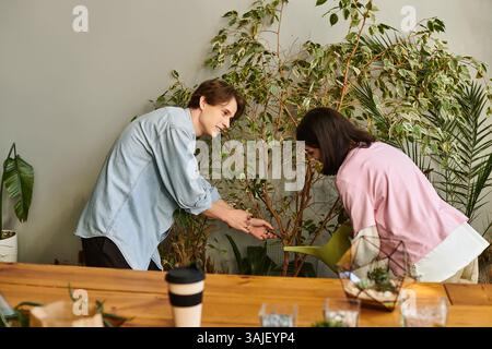 Creative couple collaborate, nurturing plants and sharing creative ideas in a lively studio. Stock Photo