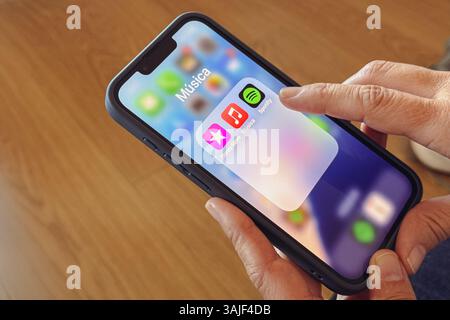 Close up of woman hands using Spotify app on iPhone Stock Photo