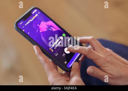 Close up of woman hands using Spotify app on iPhone Stock Photo