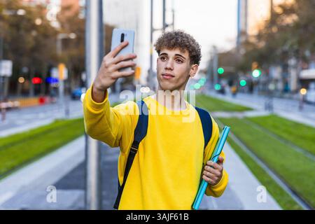 College student taking selfie with smartphone in city street Stock Photo