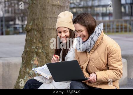 Two stundents study outdoor in the university park. Students preparing for exams with books and a laptop Stock Photo