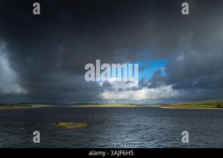 Dark ominous storm clouds gathering over Colliford Lake on the windswept Bodmin Moor in Cornwall in the UK. Stock Photo