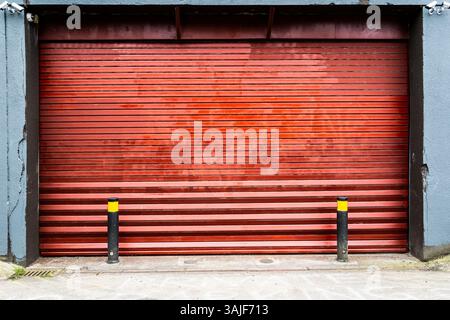 Closed shut dark red roller shutter garage doors in England in the UK. Stock Photo