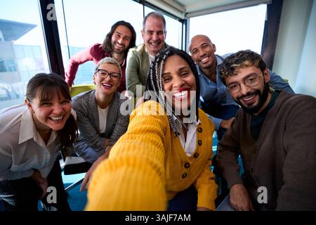 Selfie of a group of happy business people taking photo with a phone Stock Photo