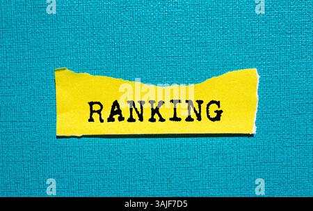Ranking message written on ripped torn yellow paper piece on blue background. Conceptual ranking symbol. Copy space. Stock Photo