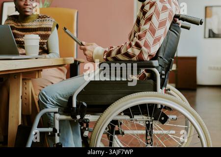 Medium close up of unrecognizable male IT specialist with disability using tablet in office Stock Photo