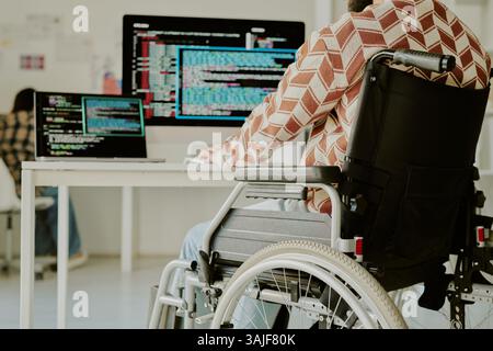 Low angle shot of unrecognizable programmer with disability coding on computer at work desk in spacious office Stock Photo