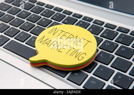 Yellow speech bubble on top of laptop keyboard with text INTERNET MARKETING. Business and technology concept. Stock Photo