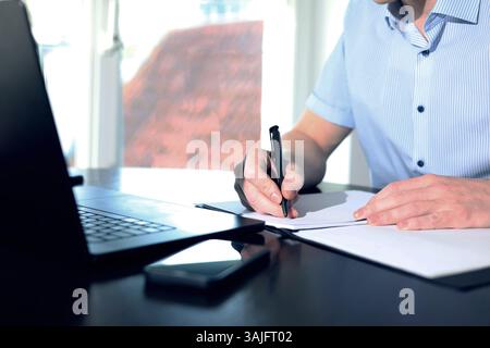 online meeting, man sitting in front of laptop and talking with team members Stock Photo