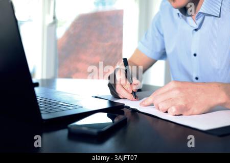 doctor working on laptop, taking notes about patient Stock Photo