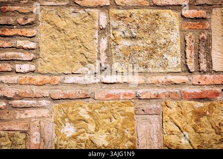 Close-up of a rustic stone and brick wall with irregular patterns and earthy tones. Aged masonry texture ideal for backgrounds, 3D rendering, or archi Stock Photo