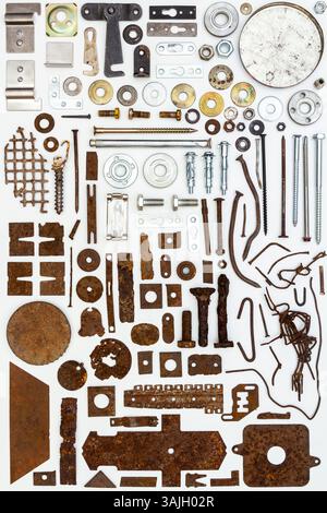 A group of various old and new bits and pieces arranged on white. Old rusty nuts, bolts, nails and other parts flay lay on white background. Stock Photo