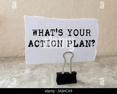 What's your action plan message written on ripped torn white paper piece on wall background. Conceptual what's your action plan symbol. Copy space. Stock Photo