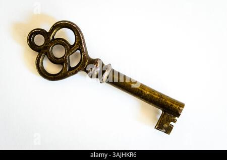Antique Brass Skeleton Key on White Background, shown at an angled  side view macro closeup Stock Photo