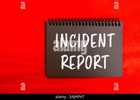 Incident report message written on black notebook page on red background. Conceptual incident report symbol. Copy space. Stock Photo
