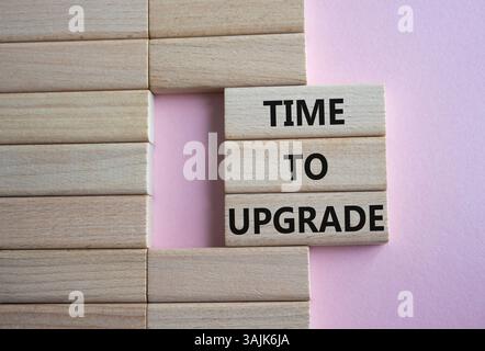 Time to Upgrade symbol. Concept words Time to Upgrade on wooden blocks. Beautiful pink background. Business and Time to Upgrade concept. Copy space. Stock Photo