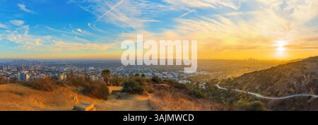 Los Angeles, California - December 3, 2024: Wide-angle panoramic view captures the vibrant sunset illuminating the Los Angeles skyline from Runyon Can Stock Photo