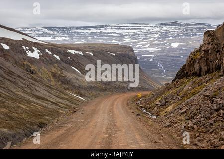 Dirt winding road through the rugged mountains covered with snow in Patreksfjordur, Westfjords, Iceland. Stock Photo