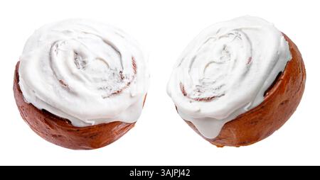 Tasty cinnamon rolls with cream in air on white background Stock Photo