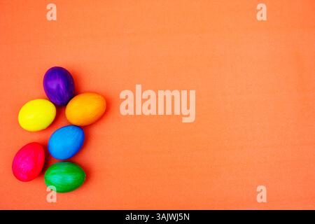 Handmade Multicolored  Easter Eggs isolated On Plain Orange Backgound. Multiple dyed eggs placed on a simple background with , giving a natural yet fe Stock Photo