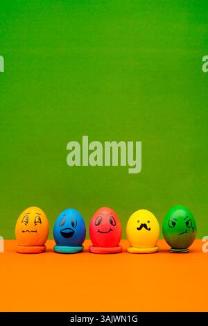 A set of vibrant and quirky emoji eggs designed for festive, cheerful Easter decoration. Easter Eggs With Cute Faces On Vibrant Background Stock Photo