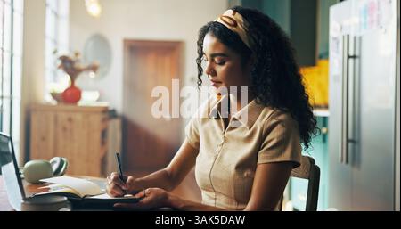 Girl, student and writing notes with book in home for online course, e learning and study in morning. Woman, notebook and editing project by pc for Stock Photo