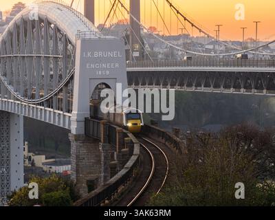 GWR Class 43 headed HST crossing over the Royal Albert Bridge from Saltash to Plymouth over the River Tamar at sunset Stock Photo