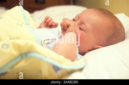 sick baby lying in bed Stock Photo