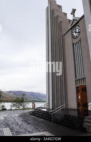 Akureyri, Iceland - 13. June 2024: Modern concrete church with clock tower rising above the town of Akureyri, Iceland Stock Photo