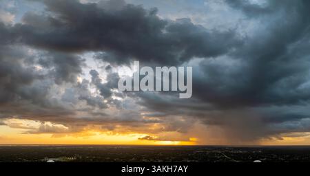 Tropical storm in Florida at sunset. Stormy clouds forming during heavy thunderstorm on dark sky. Moving and changing cloudscape weather Stock Photo