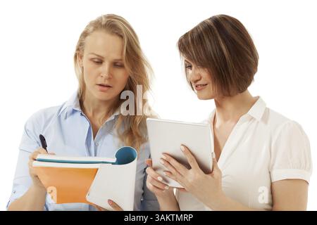 Two colleagues looking at notebook. White background. Isolated, studio shot Stock Photo