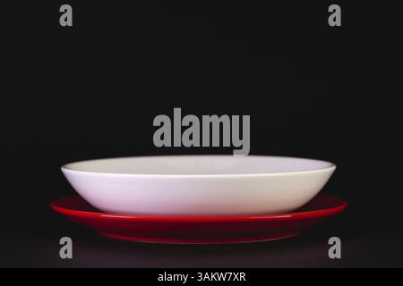 Empty red and white plates on the black background Stock Photo