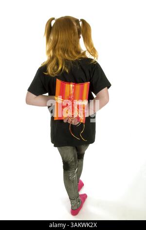 Red haired girl is hiding a present Stock Photo