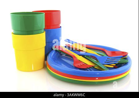 Plastic plates mugs and forks spoons and knifes in colorful plastic Stock Photo