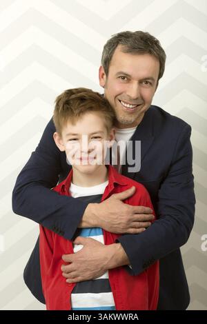 Family portrait of happy proud father hugging smiling son. Parents love Stock Photo