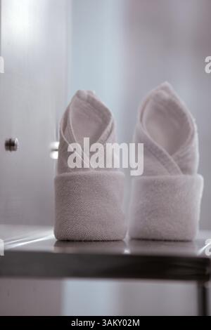 A close up of two rolled up white towels in a minimalistic interior Stock Photo