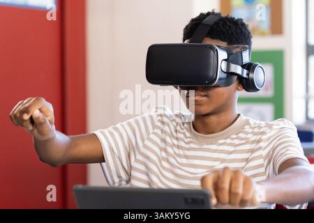 Using VR headset, boy in school engaging with virtual reality experience Stock Photo