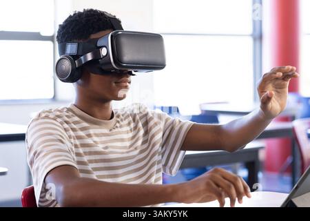 Using VR headset, student exploring virtual reality in school classroom Stock Photo