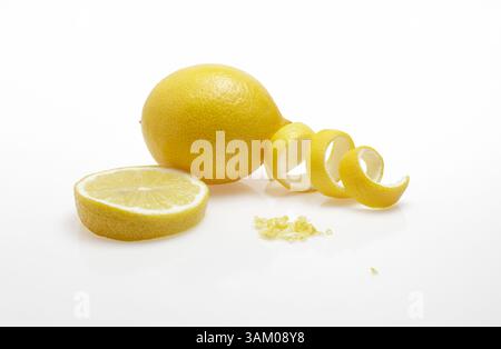 One lemon ,a slice of lemon and some lemon peel and zest on white background Stock Photo
