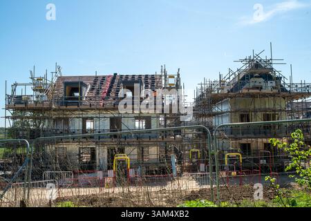 Maidenhead, Berkshire, UK. 11th April, 2025. New houses and apartments under construction in South West Maidenhead, Berkshire at the Harvest Hill site by builders Taylor Wimpey. In Labour's push to build more homes and ignore "Nimby" concerns, Chancellor Rachel Reeves has recently told builders that they can "Forget bats and newts" when they plan more houses. South West Maidenhead is becoming unrecognisable as many of the open fields are being built on. Nearby Maidenhead Golf Club is also due to have 1,500 news homes built on it too. Credit: Maureen McLean/Alamy Stock Photo