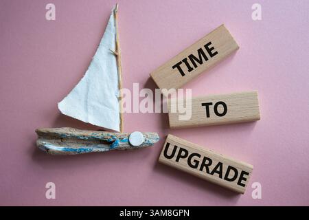 Time to Upgrade symbol. Concept words Time to Upgrade on wooden blocks. Beautiful pink background with boat. Business and Time to Upgrade concept. Cop Stock Photo