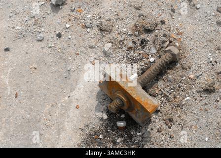 A discarded machine part lies in the gravel, rusty and marked by time - a symbol of transience, technology and industrial decay. Stock Photo