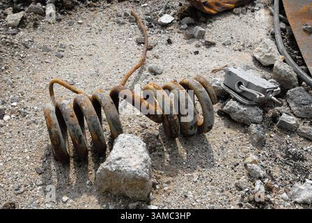 A discarded machine part lies in the gravel, rusty and marked by time - a symbol of transience, technology and industrial decay. Stock Photo